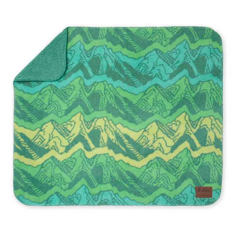 Green Stio Sherpa Fleece Blanket with a zigzag mountain pattern showing a solid green backside.