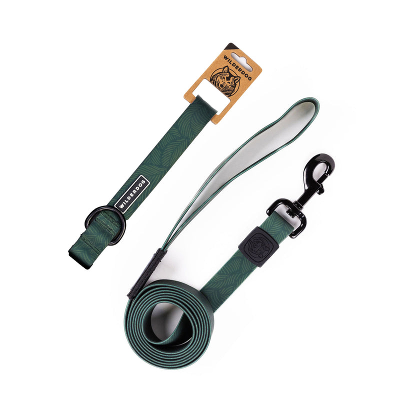 The Cedar Waterproof Leash + Collar Bundle features a green, stink-proof design with a subtle leaf pattern, black metal clasp, padded handle, and branded tag. Durable and partly coiled, it&