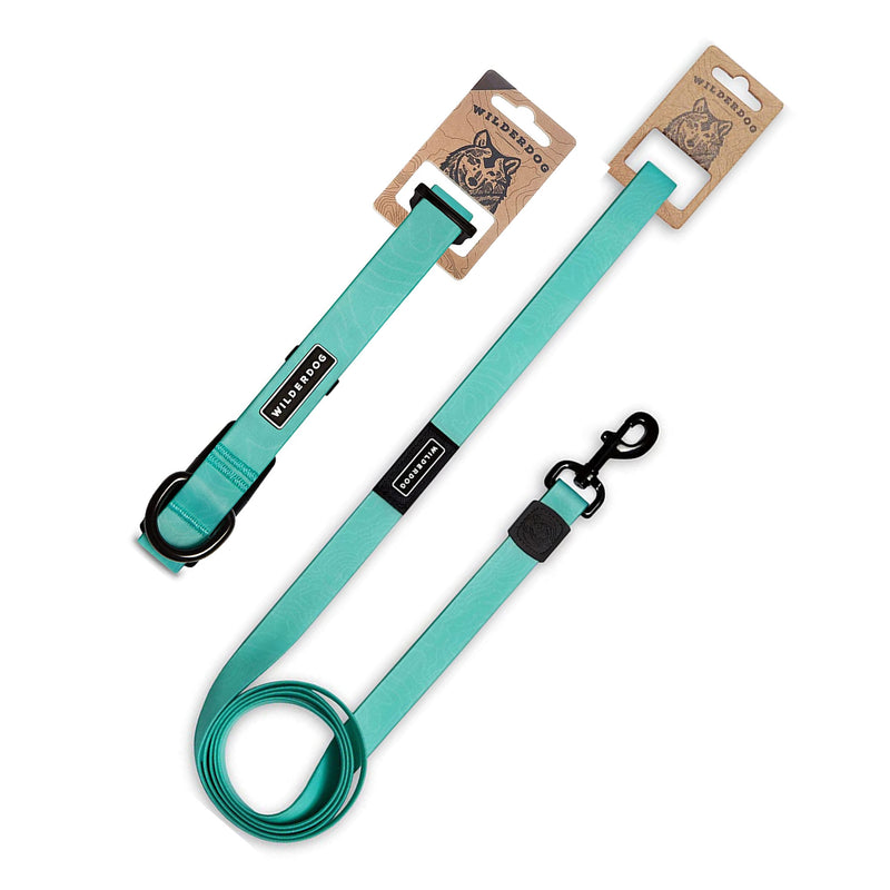 The Seafoam Waterproof Leash + Collar Bundle features a stink-proof teal leash with a black metal clip and buckle. It comes with branded cardboard tags displaying a dog illustration, highlighting its durable, stylish design.