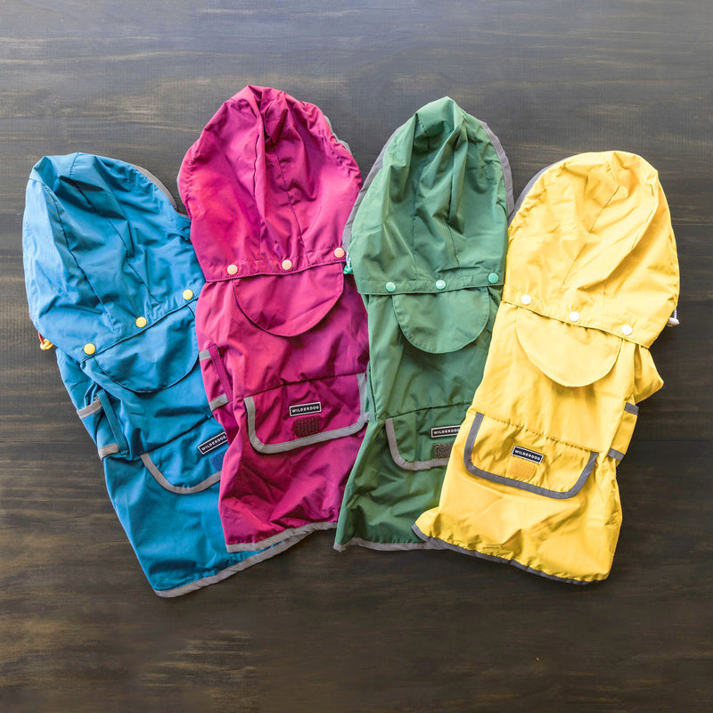 Four Dog Rain Jackets in blue, magenta, green, and yellow, with hoods, pockets, and reflective trim