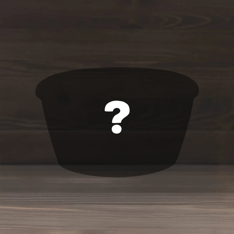 The Mystery Gift features a dark, oval-shaped container with a large white question mark at its center, set against a wooden background.