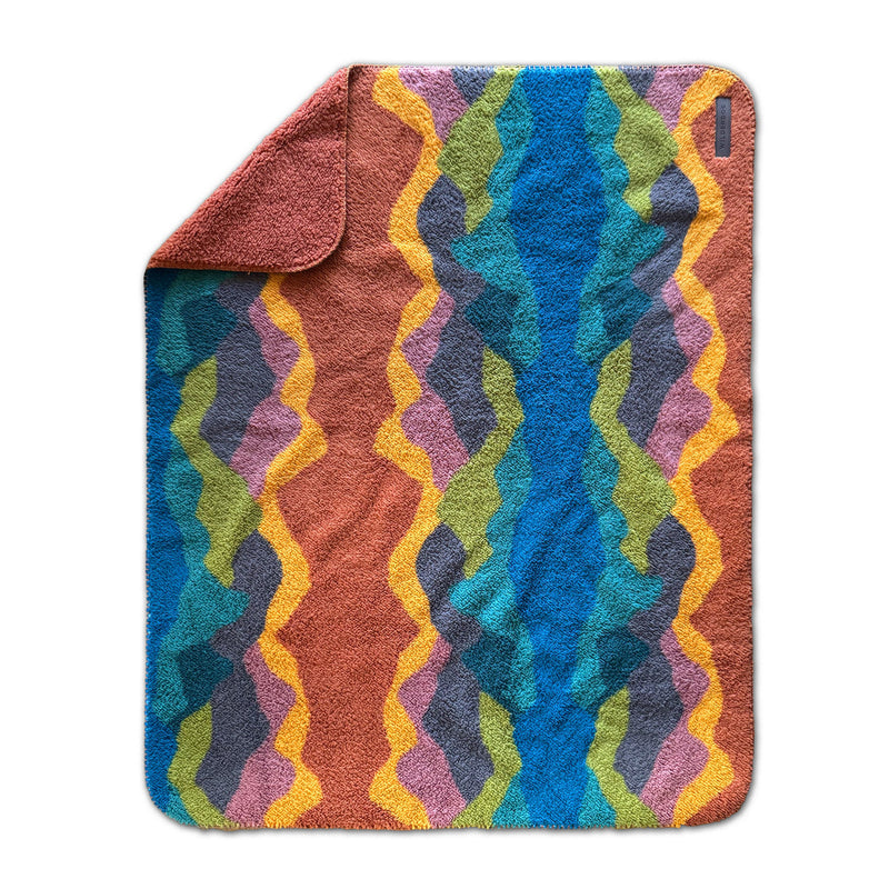 Sherpa Fleece Waterproof Blanket with colorful zigzag waves and a flipped corner for stylish comfort.